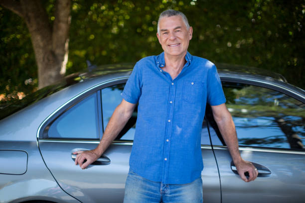 istock Smiling senior man standing by car 676593134
