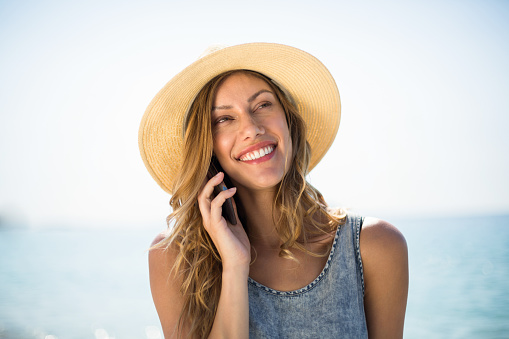 Mujer sonriendo mientras habla por teléfono móvil photo