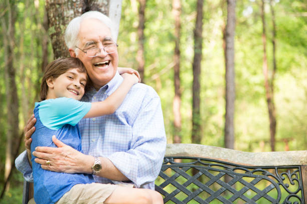 istock Grandfather and grandson hugging outdoors together. 676620924