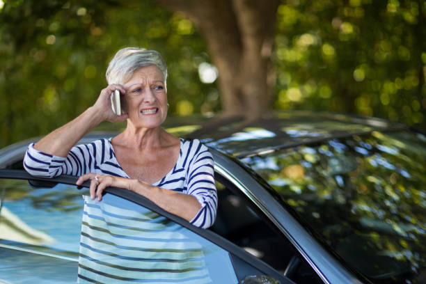 istock Senior woman talking on phone by car 676621294