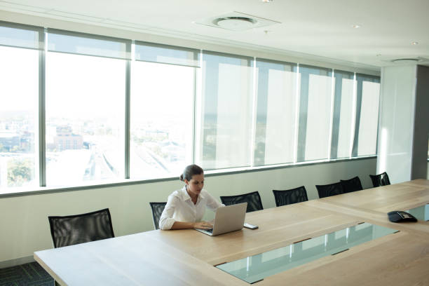 istock Businesswoman using laptop in conference room 676705024