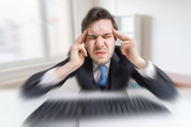 istock Young overworked man is tired by working with compuiter and suffering from headache. 676714794