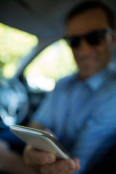 istock Man holding mobile phone in car 676748394