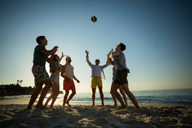 istock Friends playing volleyball on shore at beach 676759028