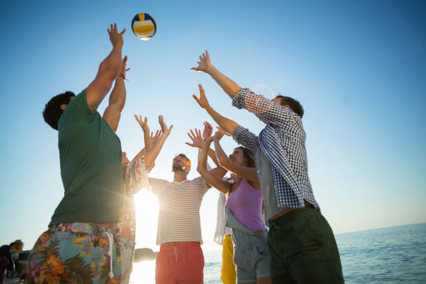 istock Low angle view of friends playing volleyball on shore 676759250