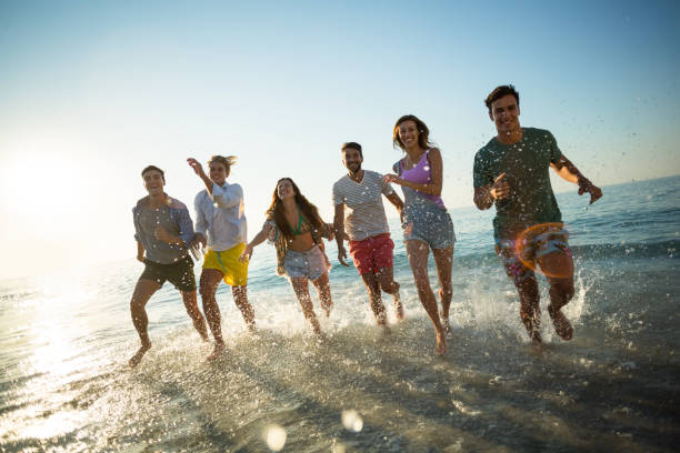 istock Friends running on shore at beach 676759754