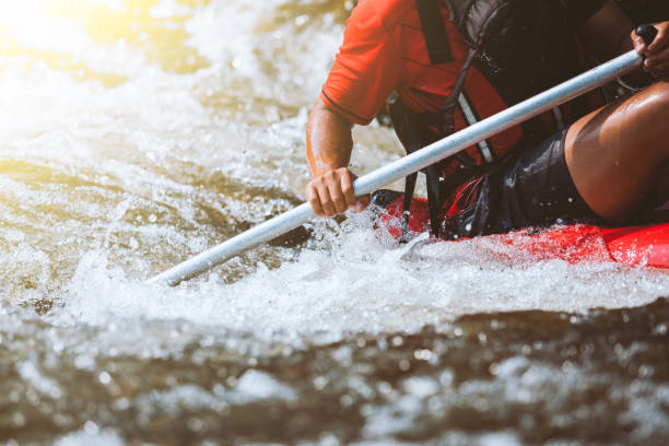 молодой человек рафтинг на реке, экстремальный и веселый спорт на туристической достопримечательности - sports team sport rowing teamwork rafting стоковые фото и изображения