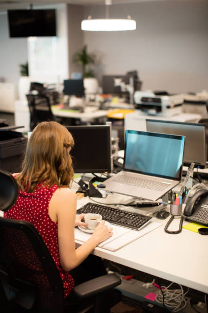 istock Businesswoman holding coffee cup while working in office 676803638
