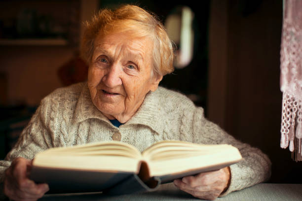 istock Retired old woman reading a book in your house. 676933754