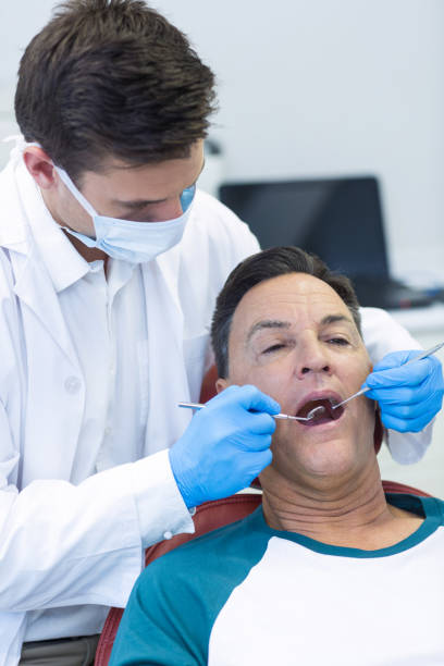 istock Dentist examining a male patient with tools 676977638