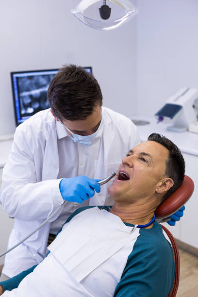 istock Dentist examining a male patient with tools 676981136