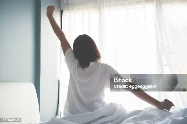 Asian Woman Waking Up In The Morning Outstretched Arms Stock Photo - Download Image Now