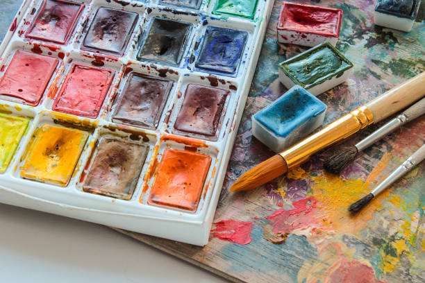 istock Watercolor paints on a white board with brush and a palette. 677036500