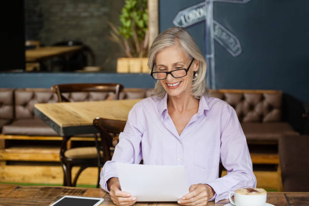 istock Smiling senior womanb holding tablet computer while sitting at table 677106108