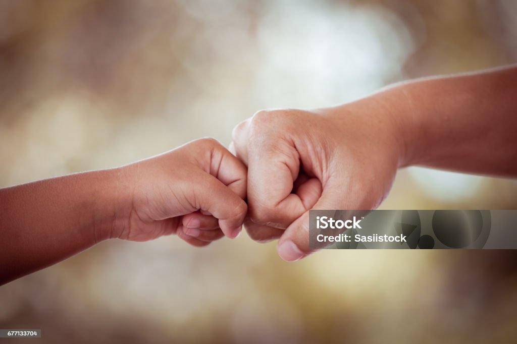 mother and kid daughter are fist bumping in vintage color tone Child Stock Photo