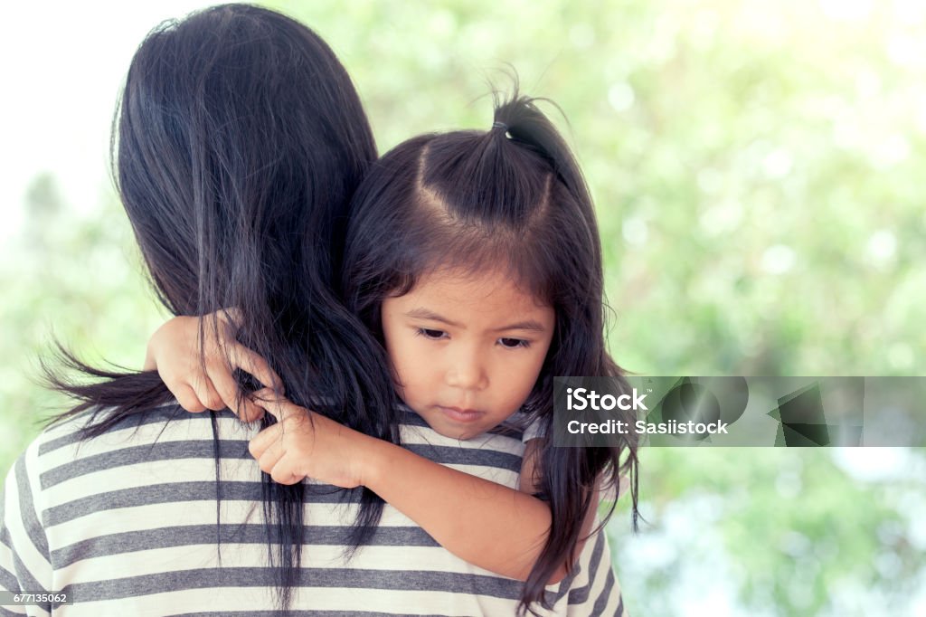 Mother and child cute little girl resting on her mother's shoulder Mother and child cute little girl resting on her mother's shoulder in vintage color tone Child Stock Photo