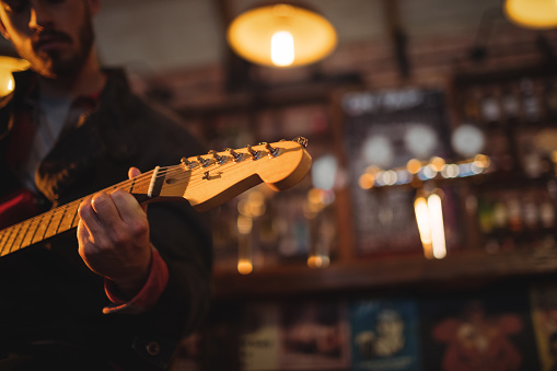 Young man playing guitar in pub