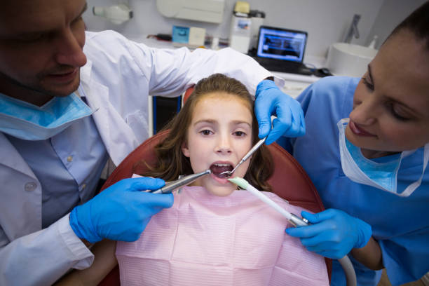 istock Dentists examining a young patient with tools 677160172