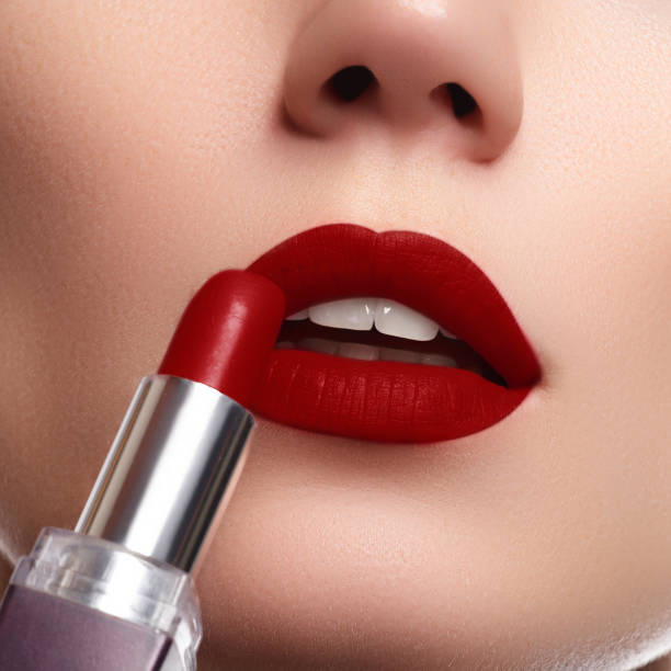 istock Extreme close up on model applying dark red lipstick. Makeup 677169466