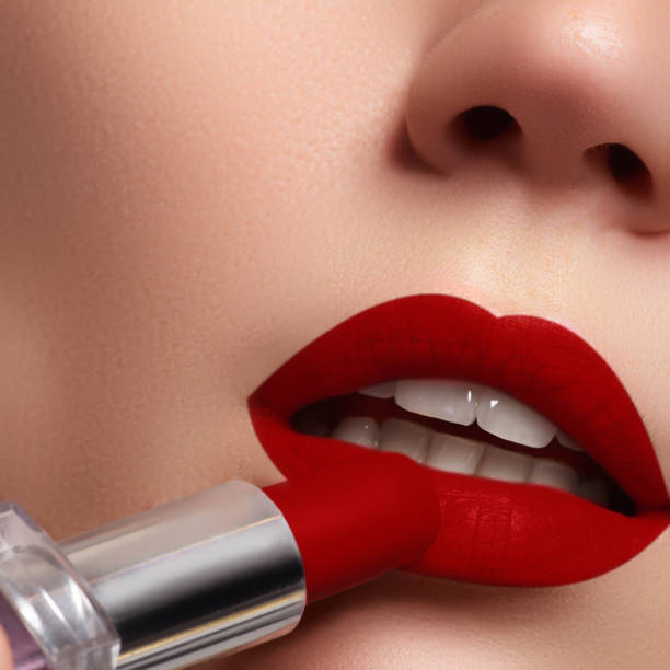 istock Extreme close up on model applying dark red lipstick. Makeup 677169482