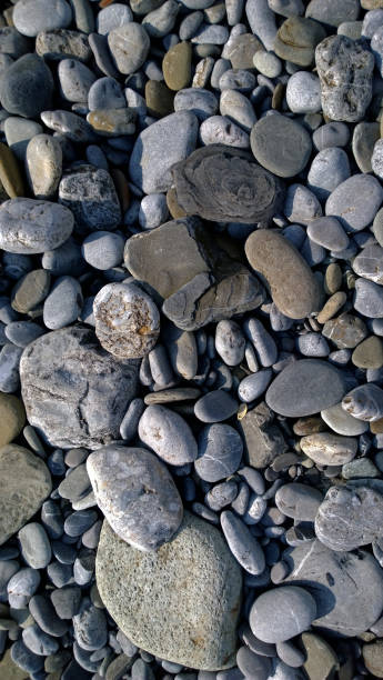istock Pebbles on the sea shore. Vertical view 677210514