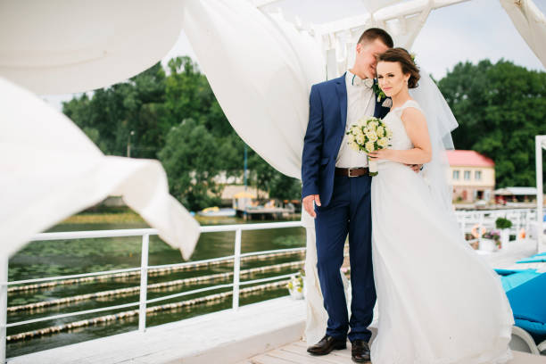 istock Charming wedding couple hugging on pier of the dock under bungalow. 677234488