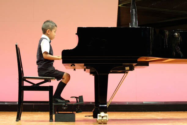 istock Japanese boy playing a piano (first grade at elementary school) 677242060