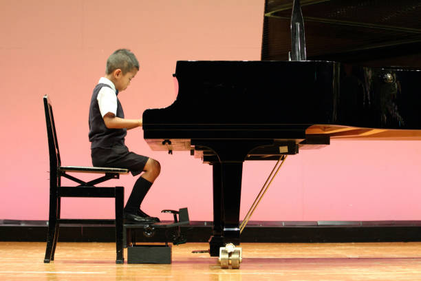 istock Japanese boy playing a piano (first grade at elementary school) 677242068