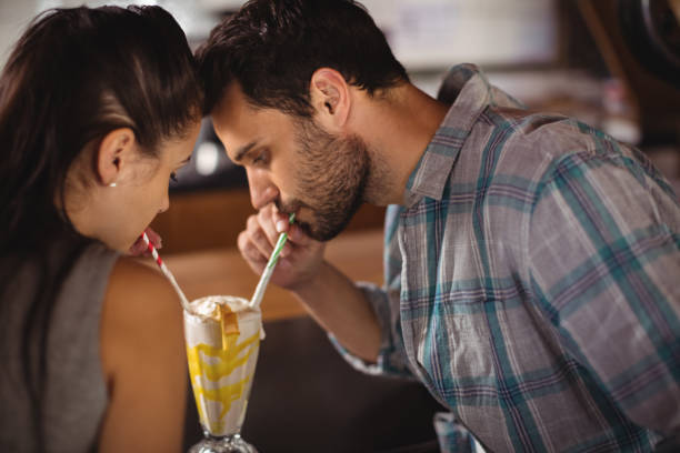 istock Close-up of couple having milkshake 677254184