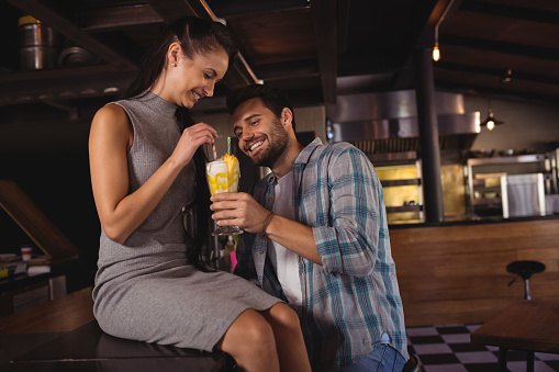 Happy couple having milkshake in restaurant