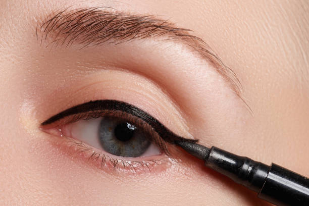 istock Beautiful model applying eyeliner close-up on eye. Make-up 677263838