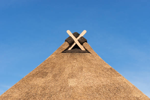 Abstract looking part of a brick house with a thatched roof in the hard midday sun