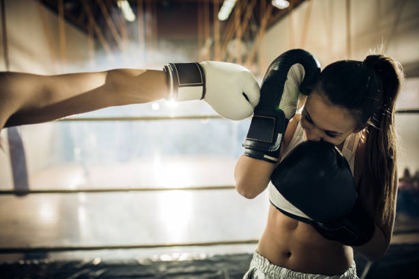 istock Female boxer blocking opponents kick during the match. 677325440