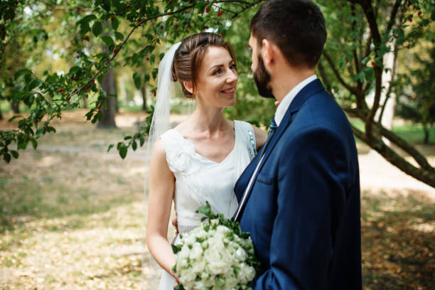 istock Wedding couple stay under tree at green park. 677327148