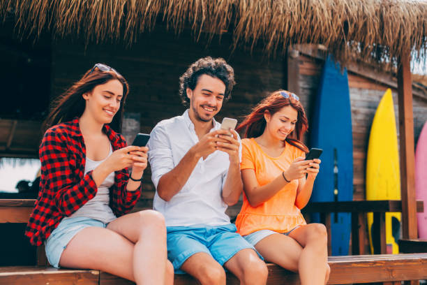 istock Friends texting at a beach bar 677327448