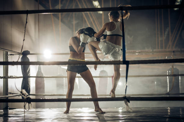 istock Female boxer attacking her opponent with jump knee kick. 677329026