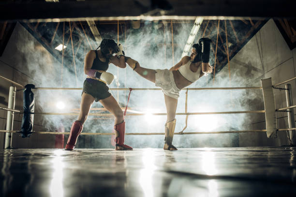 istock Two athletic women fighting on a kickboxing match in a gym. 677340940