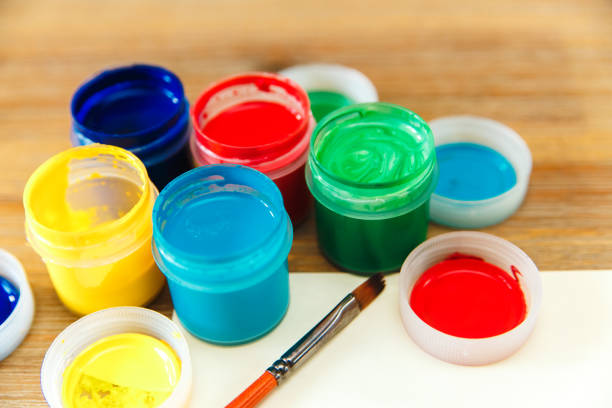 istock closeup colored cans with paint and paper.wooden table 677352826