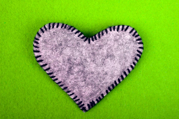 istock Gry felt heart on a green background, copy space 677375112
