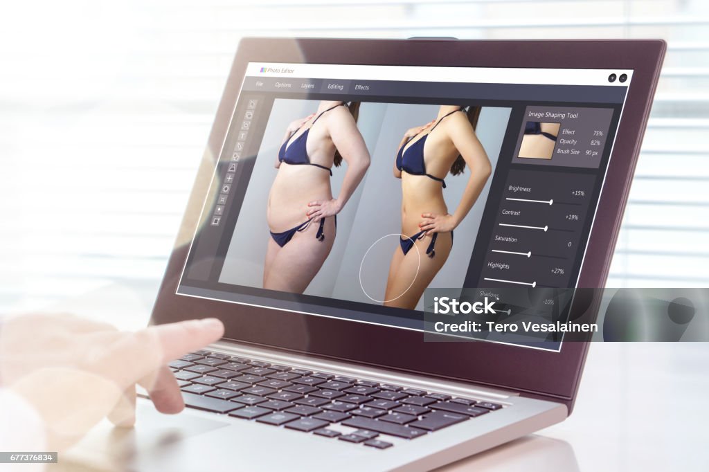 Professional man using laptop to transform chubby woman slim. Heavy photo editing with computer software. Standard of beauty, body image and post production concept. Close up of hand using laptop. Retouched Image Stock Photo