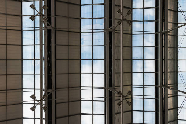 istock Roof structure of big hall with windows and blue sky 677398954
