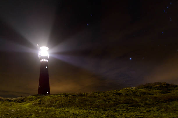 phare dans la nuit de l’île de schiermonnikoog aux pays-bas - dark light beam beacon projection photos et images de collection