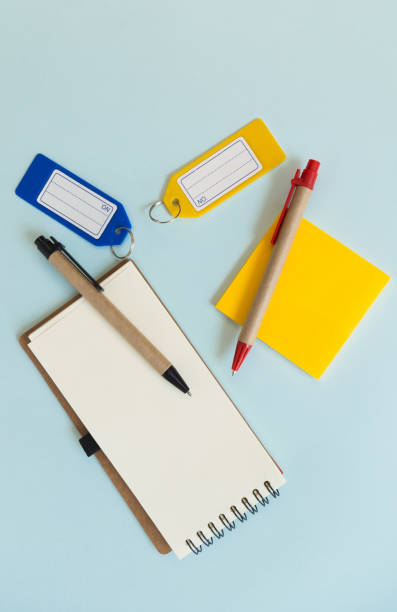 istock Notebook place on blue background with yellow, pens and plastic tags 677442982