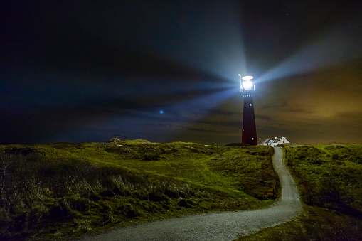 Lighthouse and fishermen's cottages in the night at the island of Schiermonnikoog in The Netherlands.