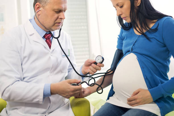 беременная женщина в кабинете врача с измеренным давлением - body care horizontal cheerful illness стоковые фото и изображения