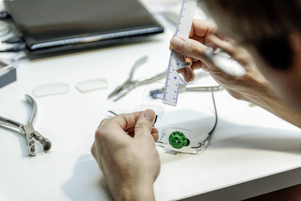 doctor making lens measurements with scale - magnifying glass lens holding europe imagens e fotografias de stock