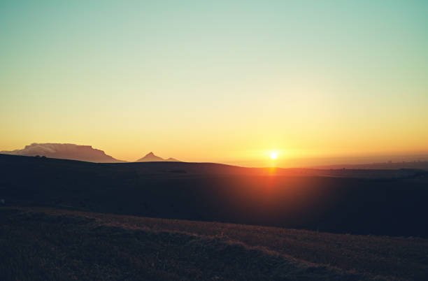 Shot of the sun setting over a beautiful rural landscape