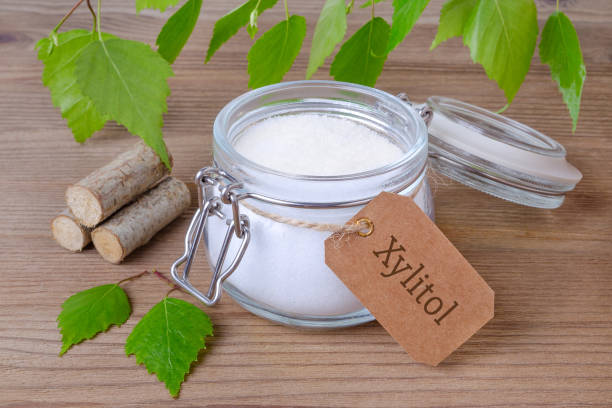 sugar substitute xylitol, a glass jar with birch sugar, liefs and wood - grain and cereal products imagens e fotografias de stock