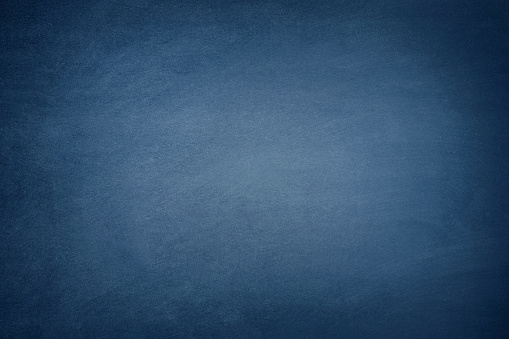 Blank blue chalkboard background with traces of erased chalk.