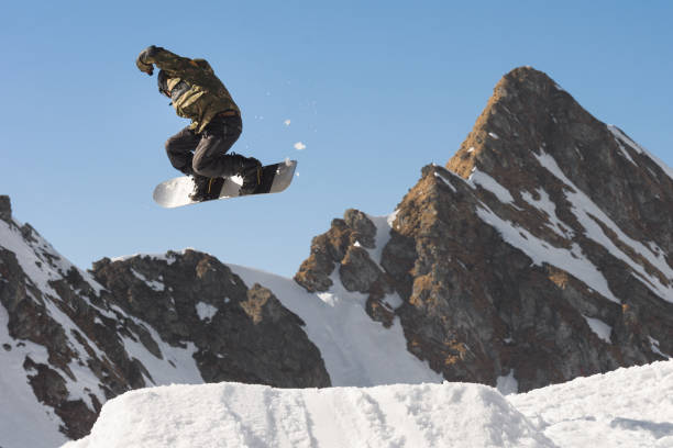 istock Male snowboarder jumping in midair while riding off piste 677519084